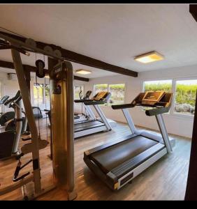 un gimnasio con varias cintas de correr y una fila de bicicletas estáticas en Linda Bay Resort y Spa Monoambiente en Mar de las Pampas