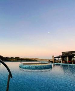una gran piscina de agua azul con edificios al fondo en Linda Bay Resort y Spa Monoambiente en Mar de las Pampas