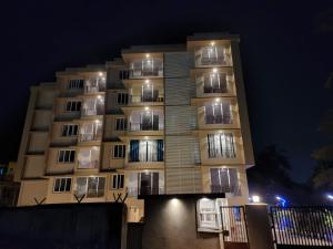 um edifício alto à noite com luzes acesas em MYKA SD ZANITA HEIGHTS em Vasco Da Gama