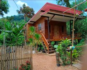 a wooden house with a wooden staircase leading to it at Easy Life Country House in Ko Lanta