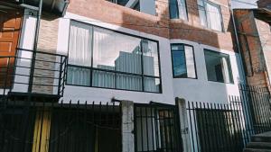 a building with glass windows and a fence at Departamento: Mirador de Puno. in Puno