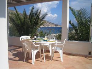 einen Tisch und Stühle auf einer Terrasse mit Meerblick in der Unterkunft Casa Poseidon in Hvar