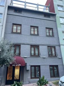 a tall gray building with a red awning at ComeLiveGO Cihangir 31 in Istanbul