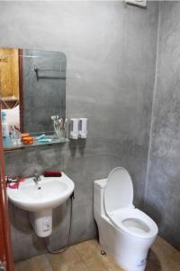 a bathroom with a white toilet and a sink at Easy Life Country House in Ko Lanta