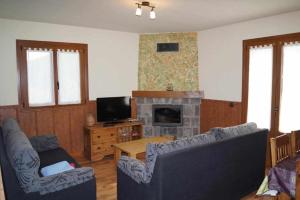 a living room with two couches and a fireplace at Amalur Irati in Ezcároz