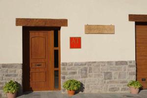 a door and a sign on a wall with plants at Amalur Irati in Ezcároz