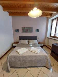 San Colombano al Lambro的住宿－Bed & Breakfast Monti 85，一间卧室配有一张大床和两条毛巾