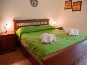 ein Schlafzimmer mit einem grünen Bett mit zwei Handtüchern darauf in der Unterkunft VILLA ANGELA TRABIA in Trabia