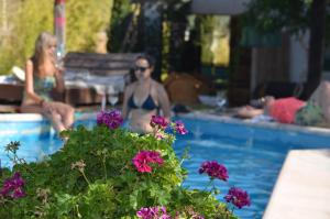 una mujer en bikini en una piscina con flores en Casa con piscina a 5 minutos del centro en El Challao