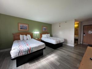 a hotel room with two beds and a bathroom at Regency Inn and Suites in Stilwell