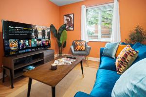 a living room with a blue couch and a tv at Luxury 2 Bedroom Apartment - Parking - Nr Birmingham City Centre - 2WH - Top Rated in Birmingham