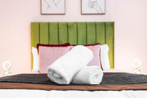 uma pilha de toalhas sentadas em cima de uma cama em Luxury 2 Bedroom Apartment - Parking - Nr Birmingham City Centre - 2WH - Top Rated em Birmingham