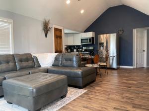 uma sala de estar com um sofá de couro e uma cozinha em Lush Wonders - Sleeps 7, Wi-Fi, Pet-friendly, Free Parking, BBQ em Springfield
