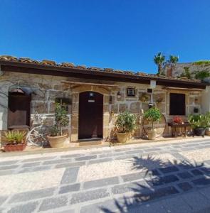 una casa con macetas delante de ella en One bedroom house with enclosed garden at Avola 2 km away from the beach, en Avola