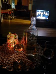 a bottle of alcohol and two glasses on a table at Apartament Szóstka nad Sołą in Czaniec