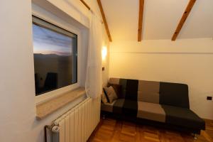 Habitación con sofá frente a una ventana en Apartman Miramare, en Otočac