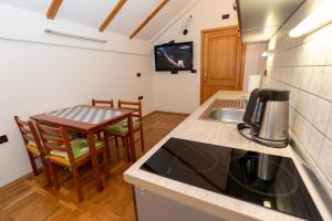 a kitchen with a sink and a table with chairs at Apartman Miramare in Otočac