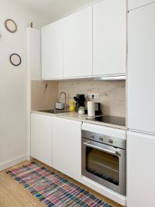 a kitchen with white cabinets and a stainless steel oven at Casa Alta in Castelo de Vide