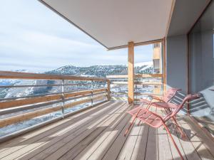 a balcony with two chairs and a view of the mountains at Bel appartement neuf 8 pers, proche pistes, parking inclus - FR-1-645-49 in LʼHuez