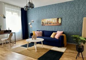 un soggiorno con divano blu e tavolo di Die Stadtkanzlei a Klagenfurt