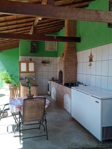 a kitchen with a table and a brick oven at Happy Place Itaúna Saquarema in Saquarema
