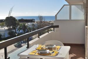 a table with a plate of food on a balcony with the ocean at Apartment At Monte Gordo Beach Ocean View in Monte Gordo