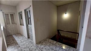 a hallway with two doors and a room with a bed at Will's House in São Luís