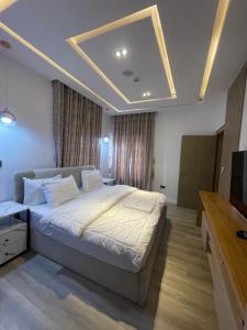 a bedroom with a large bed and a television at Casalavoro apartments in Abuja