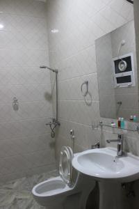 a bathroom with a toilet and a sink at أمجاد للشقق الفندقية in Al Ḩuwayl