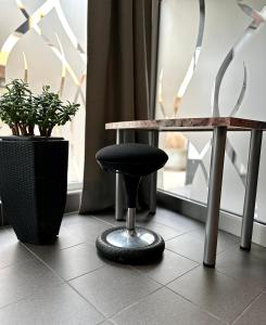 a table and a black stool next to a table at Studio im Herzen Meiningen -Erdgeschoss- in Meiningen