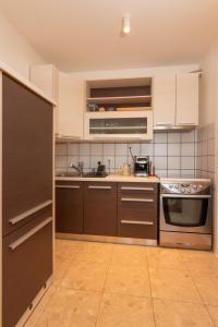 a kitchen with stainless steel appliances and brown cabinets at Apartman NEBO in Vinkovci