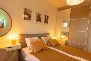 sypialnia z łóżkiem z 2 lampami i lustrem w obiekcie Apartman NEBO w mieście Vinkovci