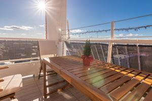 a wooden table on a balcony with a potted plant at Apartman NEBO in Vinkovci