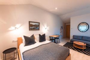 1 dormitorio con 1 cama y 1 sofá azul en Garður Stay Inn & Secret Lagoon, en Fludir
