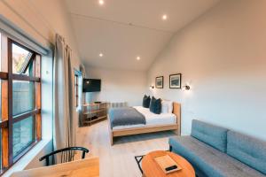 a bedroom with a bed and a couch and a table at Garður Stay Inn & Secret Lagoon in Fludir