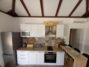 a kitchen with white cabinets and a wooden counter top at Relax in Orebić