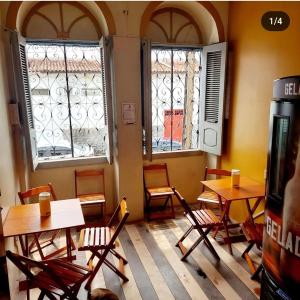 um restaurante com mesas, cadeiras e janelas em Will's House em São Luís