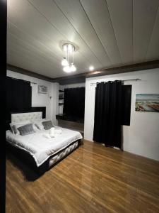 1 dormitorio con 1 cama grande y cortinas negras en Villa Valencia Private Resort en Santa Rita