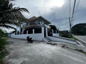una casa con una moto aparcada frente a ella en Villa Valencia Private Resort en Santa Rita