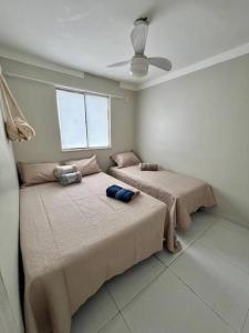 two beds in a bedroom with a ceiling at Apartamento Charmie in São Luís