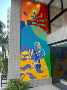 una pintura de una mujer al lado de un edificio en Hotel das Américas, en Balneário Camboriú