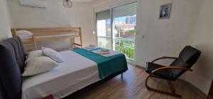 a bedroom with a bed and a chair and a window at OSA Holiday in Ulcinj