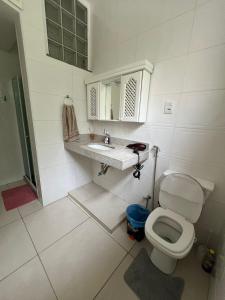 a white bathroom with a toilet and a sink at Apto Copacabana com Split e WIFI in Rio de Janeiro