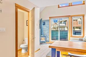 - un salon avec des toilettes et une fenêtre dans l'établissement Canmore Mountain view loft apartment heated outdoor pool, à Canmore