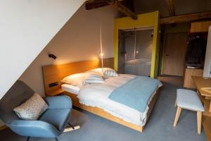 ein Schlafzimmer mit einem großen Bett und einem Stuhl in der Unterkunft TIGNUM - Übernachten mit historischem Flair in Wernigerode