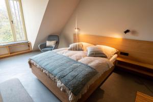 ein Schlafzimmer mit einem großen Bett mit einem hölzernen Kopfteil in der Unterkunft TIGNUM - Übernachten mit historischem Flair in Wernigerode