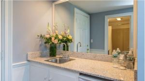 baño con lavabo y jarrón de flores en The Breakwater Inn & Spa, en Kennebunkport