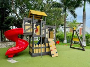 un parque infantil con tobogán y estructura de juegos en Departamento Esperanza, en Cancún