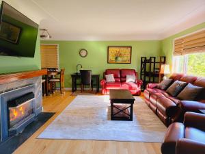 a living room with a couch and a fireplace at James Bay Inn Hotel, Suites & Cottage in Victoria
