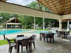 un patio con mesas y sillas junto a una piscina en Departamento Esperanza, en Cancún